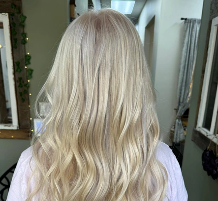Long platinum blonde hair with smooth, soft waves created at Good Vibes Salon